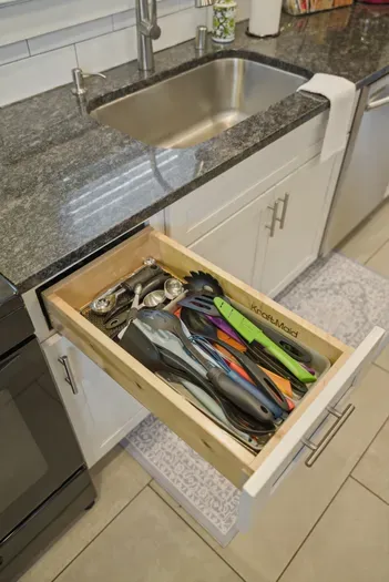 Modern kitchen with stocked utensil drawer and spacious sink
