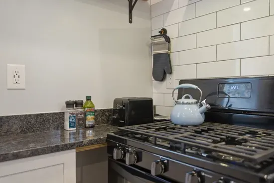 Modern kitchen with gas stove, subway tile, and guest-ready essentials