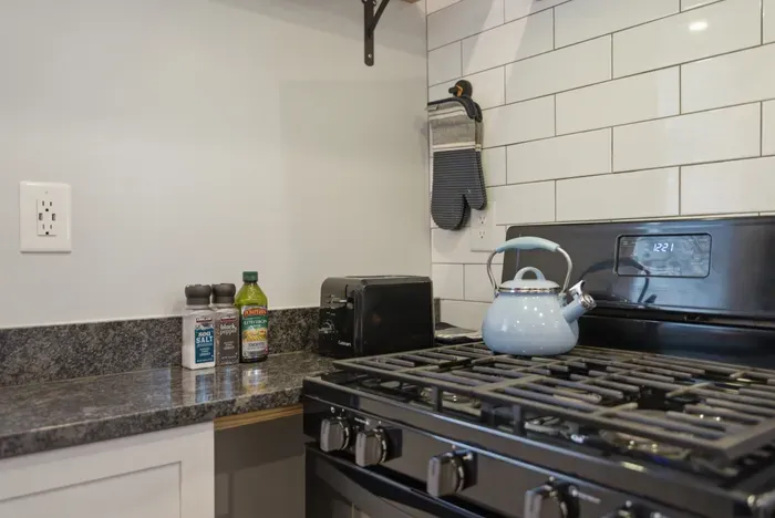 Modern kitchen with gas stove, subway tile, and guest-ready essentials