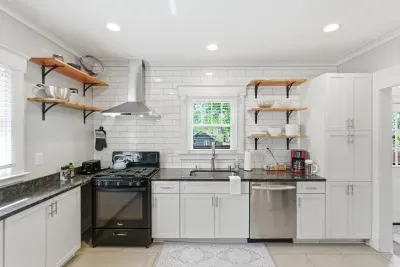 Bright modern kitchen with subway tile, open shelves, and stainless accents