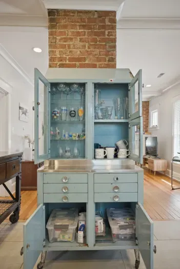 Charming blue vintage cabinet with exposed brick and bright open living space