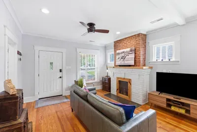 Bright living room with hardwood floors and a charming brick fireplace