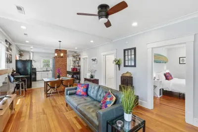 Bright open living space with hardwood floors, dining area, and cozy bedroom access