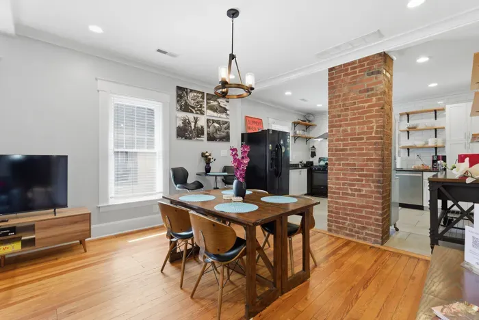 Bright dining space with exposed brick and open-concept kitchen