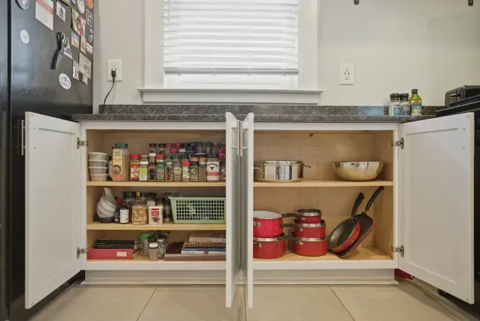 Well-stocked kitchen cabinets with cookware, spices, and meal-prep essentials