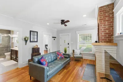 Bright living room with hardwood floors and charming exposed brick fireplace