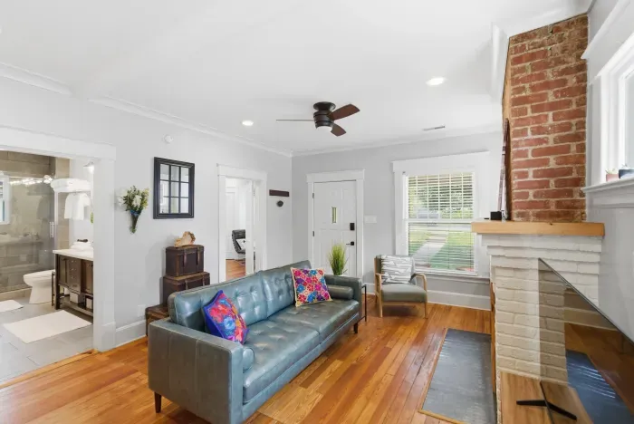 Bright living room with hardwood floors and charming exposed brick fireplace