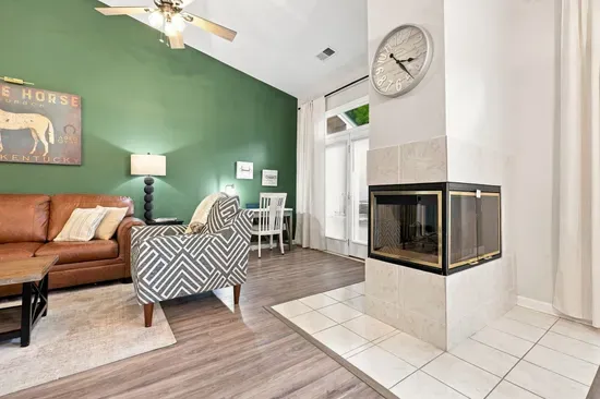 Bright living room with soaring ceilings, cozy fireplace, and desk nook