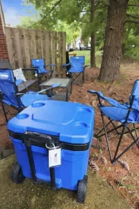 Shaded backyard hangout with camp chairs, table, and rolling cooler