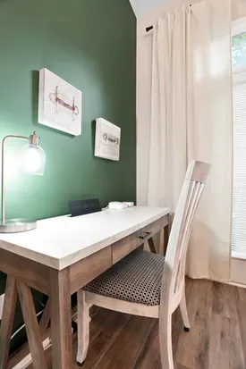 Bright, stylish workspace nook with desk, natural light, and accent wall