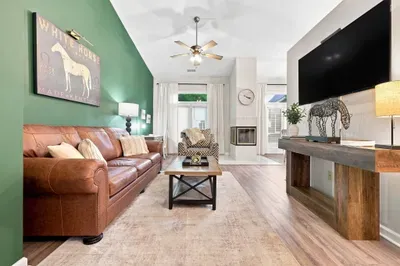 Stylish living room with leather sofa, fireplace, and large TV