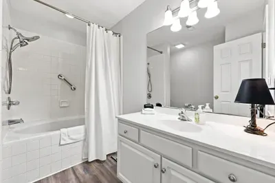 Bright full bathroom with spacious vanity and tub-shower combo