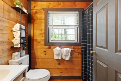The bright and functional bathroom features a full tub/shower combo, soft towels, and mountain-cabin charm.