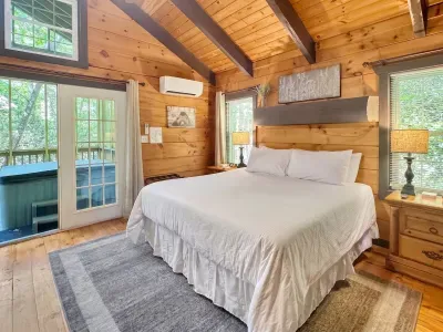 Another view of the bedroom’s rustic charm. Vaulted ceilings, soft lighting, and peaceful woods outside your window.