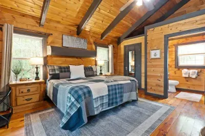 Another view of the bedroom’s rustic charm. Vaulted ceilings, soft lighting, and peaceful woods outside your window.