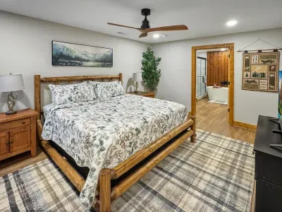 Your rustic mountain sanctuary. 🏔️ Unwind in this spacious king suite featuring a beautiful log-frame bed and local art. The open flow leads directly to your spa-like en-suite, creating the perfect private retreat within the home.