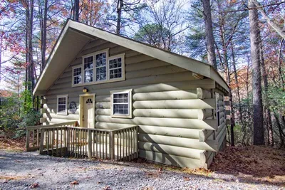 Charming exterior view of the cabin nestled in the woods.