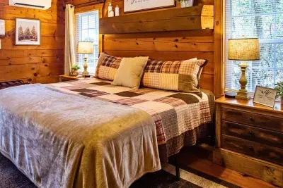 Cozy king bedroom with warm cabin charm, natural light, and peaceful views.