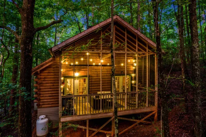Secluded vacation rental cabin with screened porch and string lights in the North Georgia Mountains.
