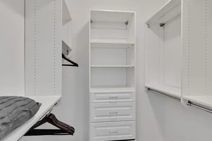 Enjoy the convenience of a spacious walk-in closet with built-in shelving and ample hanging space
