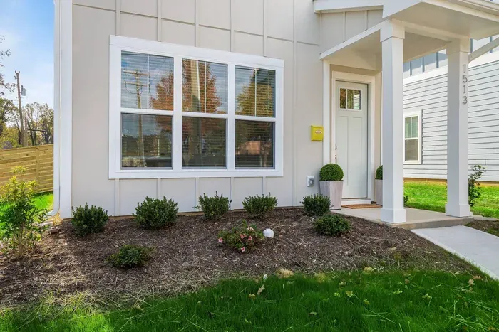 A bright, inviting entrance with well-kept landscaping and a cozy front porch to greet you upon arrival