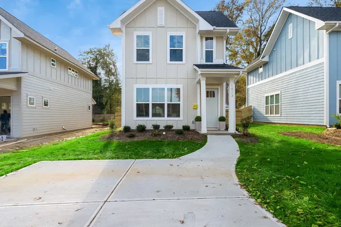 Modern home with a private driveway, charming front porch, and well-kept yard