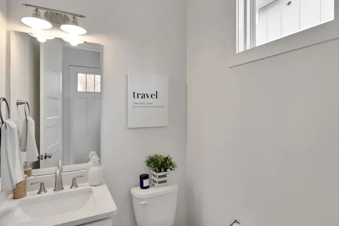 Experience a spotless water closet featuring modern fixtures, bright lighting, and a comfortable layout for your convenience.