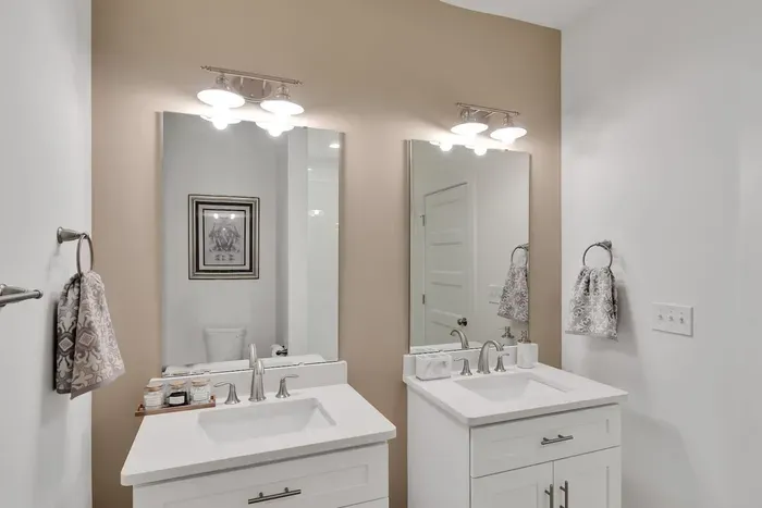Refresh and get ready in this modern bathroom featuring dual sinks, bright lighting, and stylish finishes