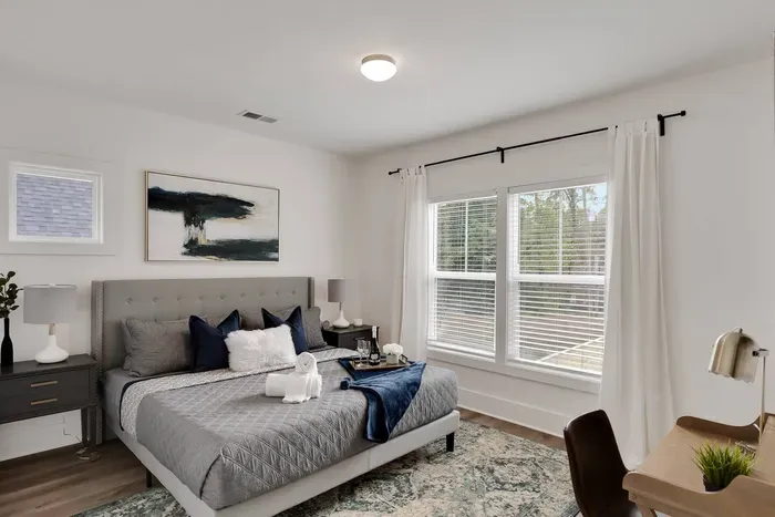 Relax in comfort and style in this bright, modern bedroom featuring a plush queen bed, cozy linens, and plenty of natural light
