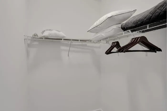 Spacious walk-in closet with hangers, extra pillows, and blankets — perfect for keeping your wardrobe organized during your stay!