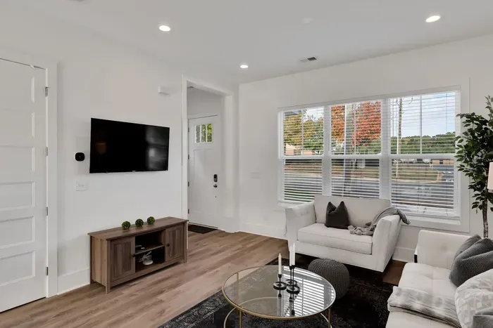 Featuring plush seating, modern décor, and a large window framing peaceful views outside.