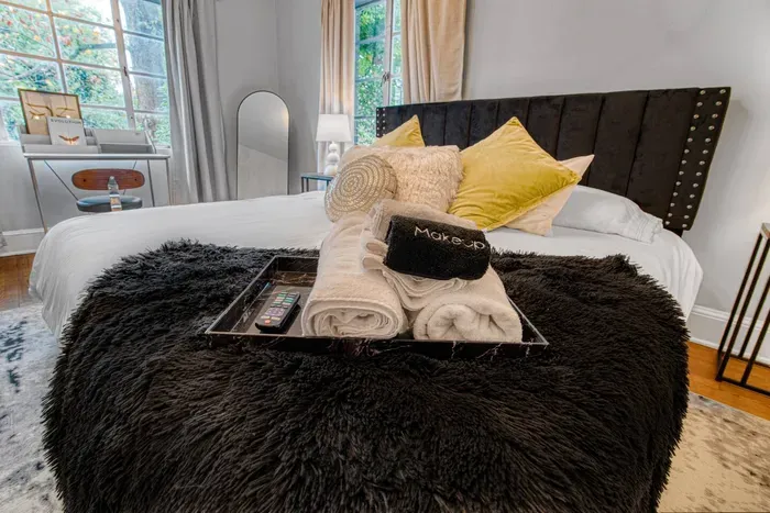 Bright, modern bedroom with a cozy bed, workspace by the window, and smart TV — designed for comfort and productivity.