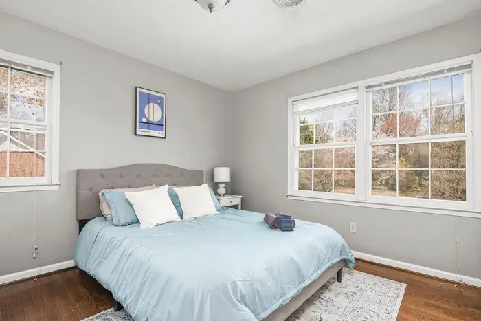 Bright airy bedroom with queen bed, two closets, plenty of pillows, dresser and nightstand.