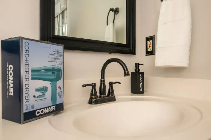 Newly renovated master bathroom with double vanity and stocked with body wash, shampoo, conditioner, hair dryer and towels.
