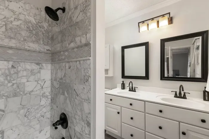 Newly renovated master bathroom with double vanity and stocked with body wash, shampoo, conditioner, hair dryer and towels.