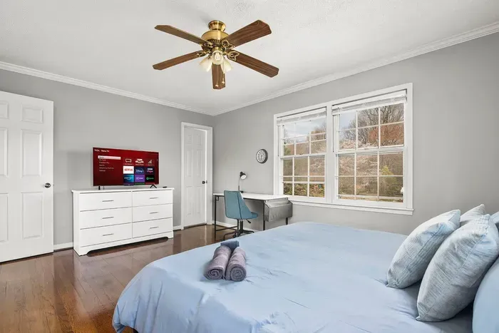 A 43-inch Smart TV sits on top of the dresser. The door on the right leads to the master bathroom.