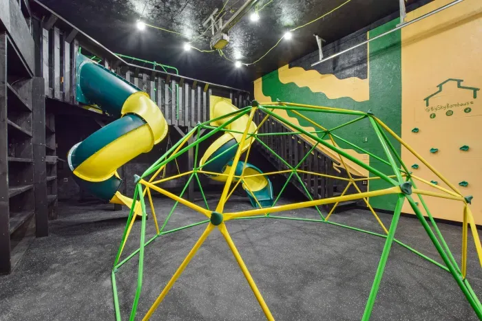 Fully equipped indoor commercial park and playground with 2 tube slides, a hexagon climbing dome, rock climbing wall, 3 tire swings and a 15ft monkey bar installation. Heated and cooled year-round, located in the party shed next to the plunge pool.