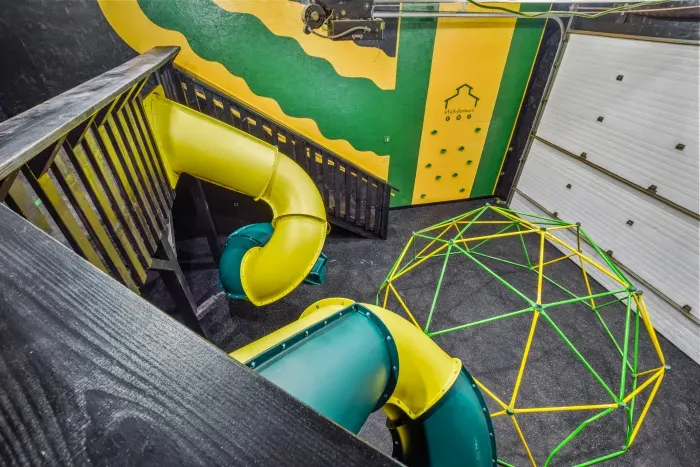 Fully equipped indoor commercial park and playground with 2 tube slides, a hexagon climbing dome, rock climbing wall, 3 tire swings and a 15ft monkey bar installation. Heated and cooled year-round, located in the party shed next to the plunge pool.