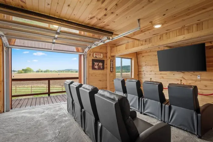 Private movie theater with a glass garage down leading out to a balcony with valley views