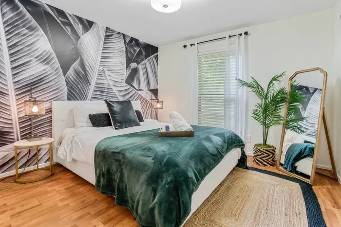 Relax in the uniquely curated design of the queen bedroom with queen bed, plenty of pillows, two nightstands, 40" Roku TV, and workstation.