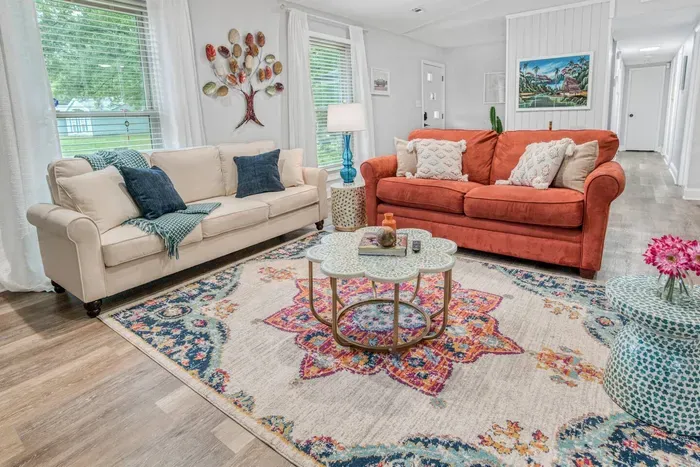 Living room seating, pillows for comfort, and a thick throw blanket. The red sofa can be pulled out into a full bed. Bedding for the pull out is kept in the laundry room. 