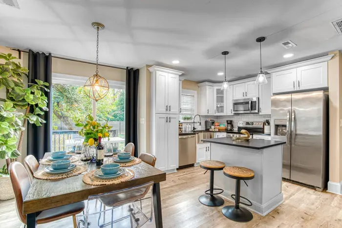 Bright dining area with a stylish table set for six, plus two additional seats at the kitchen island