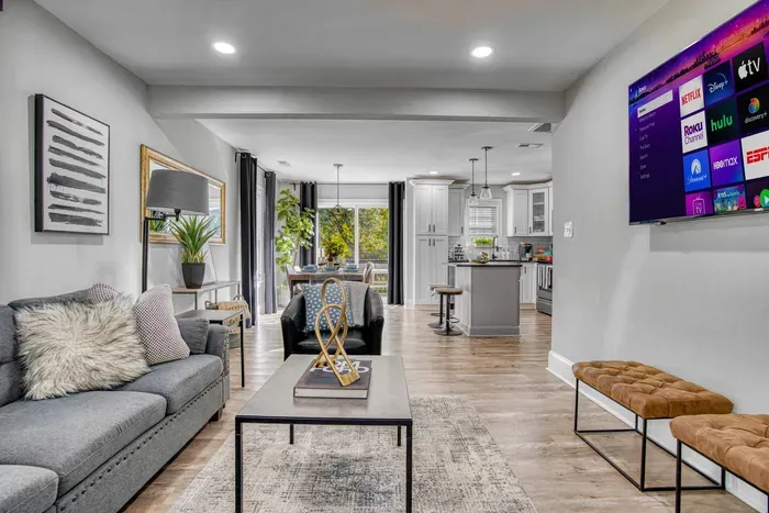 Living space with contemporary décor, comfortable seating, and a large smart TV — seamlessly connecting to the dining area and kitchen for a warm, inviting atmosphere.