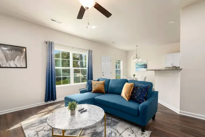 Stylish living room with a plush blue sofa, modern decor, and a 65 inch Roku TV.
