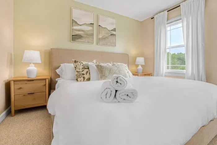 King-sized bedroom with a neutral toned walls and carpet, creating a warm atmosphere