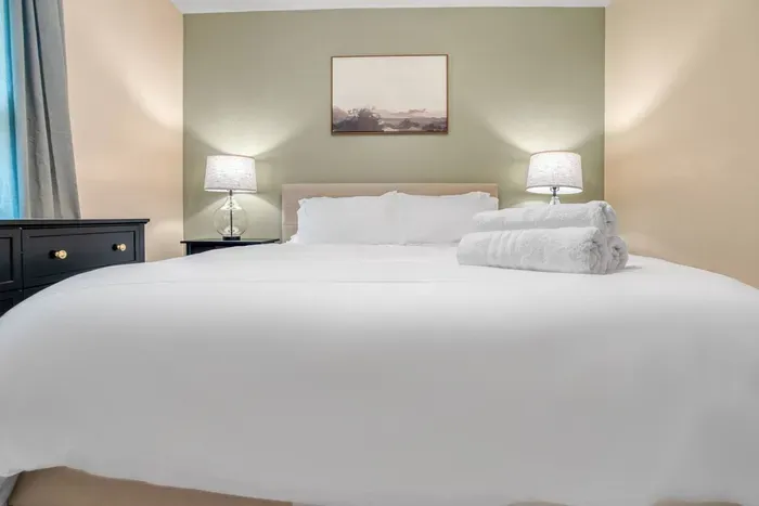 Bedroom with a plush king bed, soft lighting, and fresh linens—your perfect retreat for restful nights.