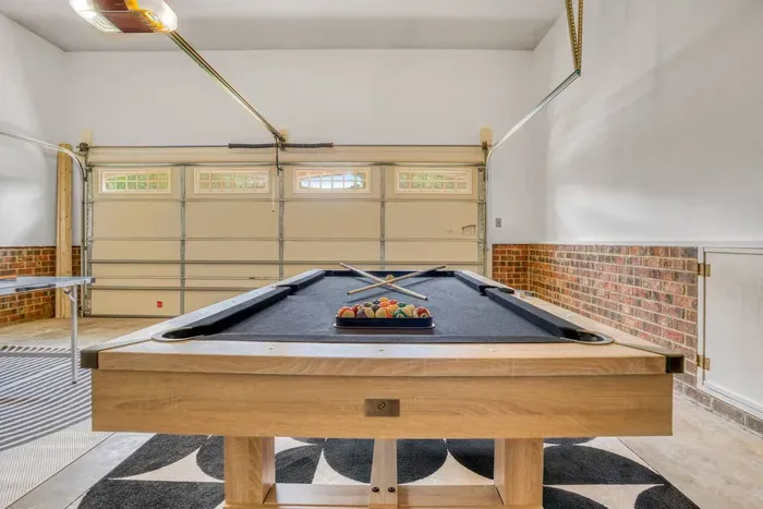 A sleek game room featuring a modern pool table in a bright, open space — perfect for friendly matches and endless fun with family or friends.