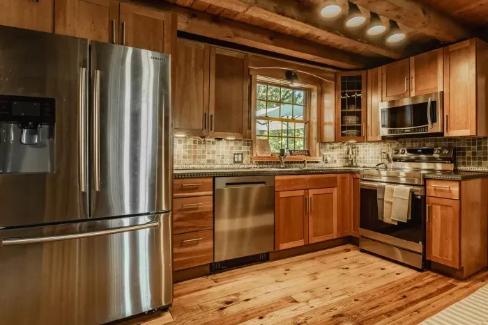 Stylish kitchen featuring stainless steel appliances, rich wood finishes, and warm lighting—perfect for cooking!