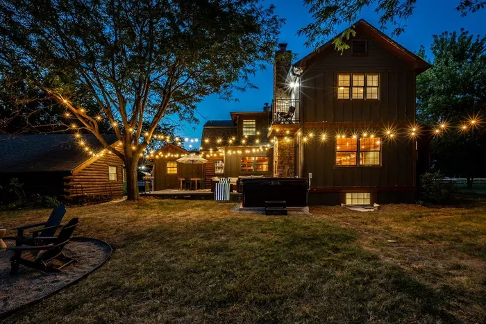 The backyard glows beautifully at night, with warm string lights creating a cozy and inviting outdoor retreat.