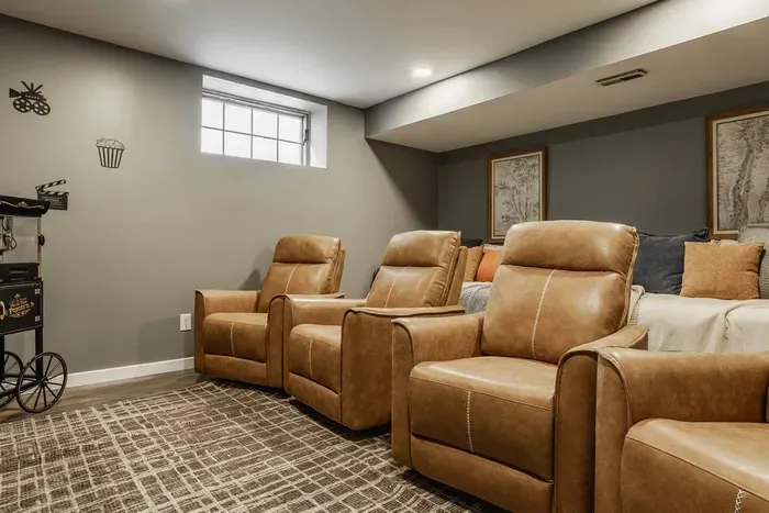 Home theater with plush leather recliners and a classic popcorn cart for the perfect movie night experience.